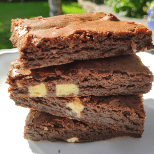 3 triple chocolate brownies stacked on a white plate