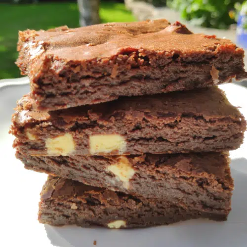 3 triple chocolate brownies stacked on a white plate