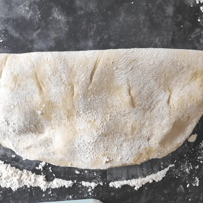 fold the chelsea bun dough in half after adding the butter muxture