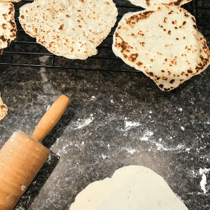 rolling out flatbreads for heating on the pan