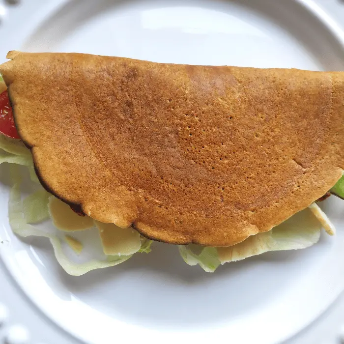 folded oat pancake with cheese, tomato and lettuce
