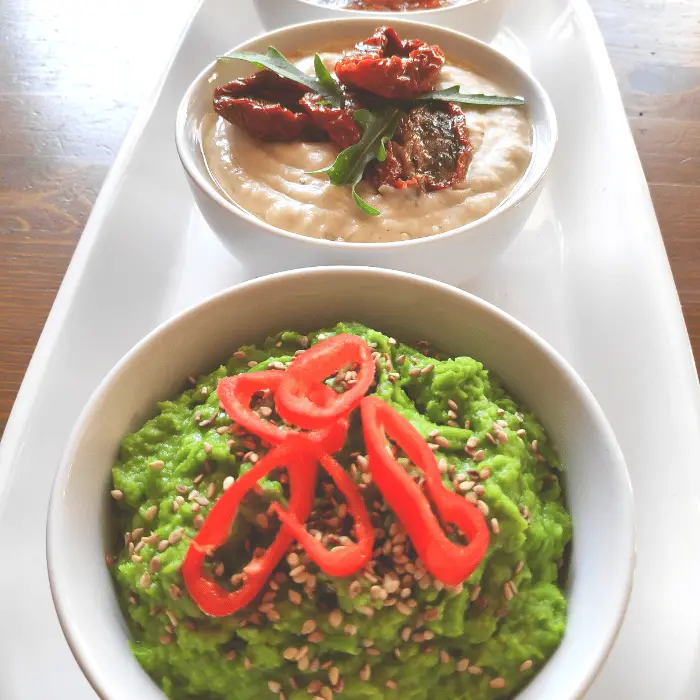 pea dip recipe uk in white bowl with sliced peppers on top