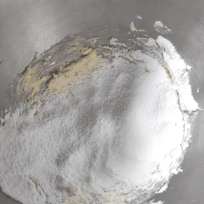 adding the icing sugar to buttercream