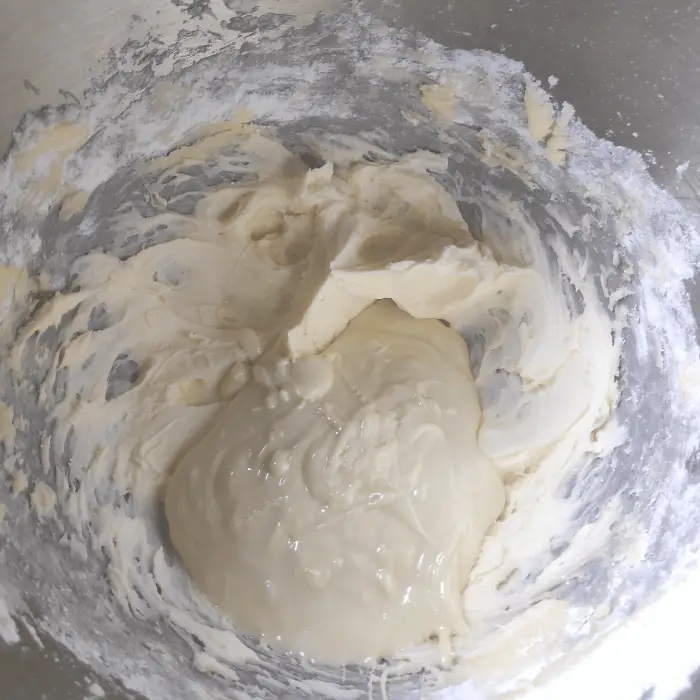 adding the melted white chocolate to buttercream