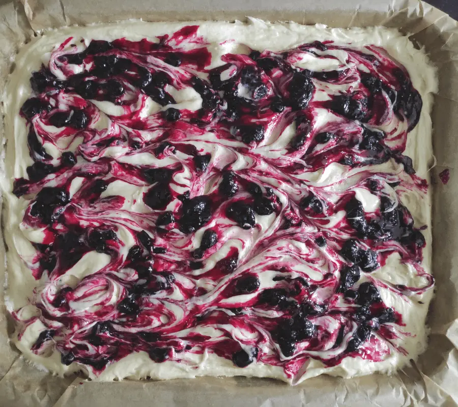 blackcurrant jam swirled on top of cake mixture traybake