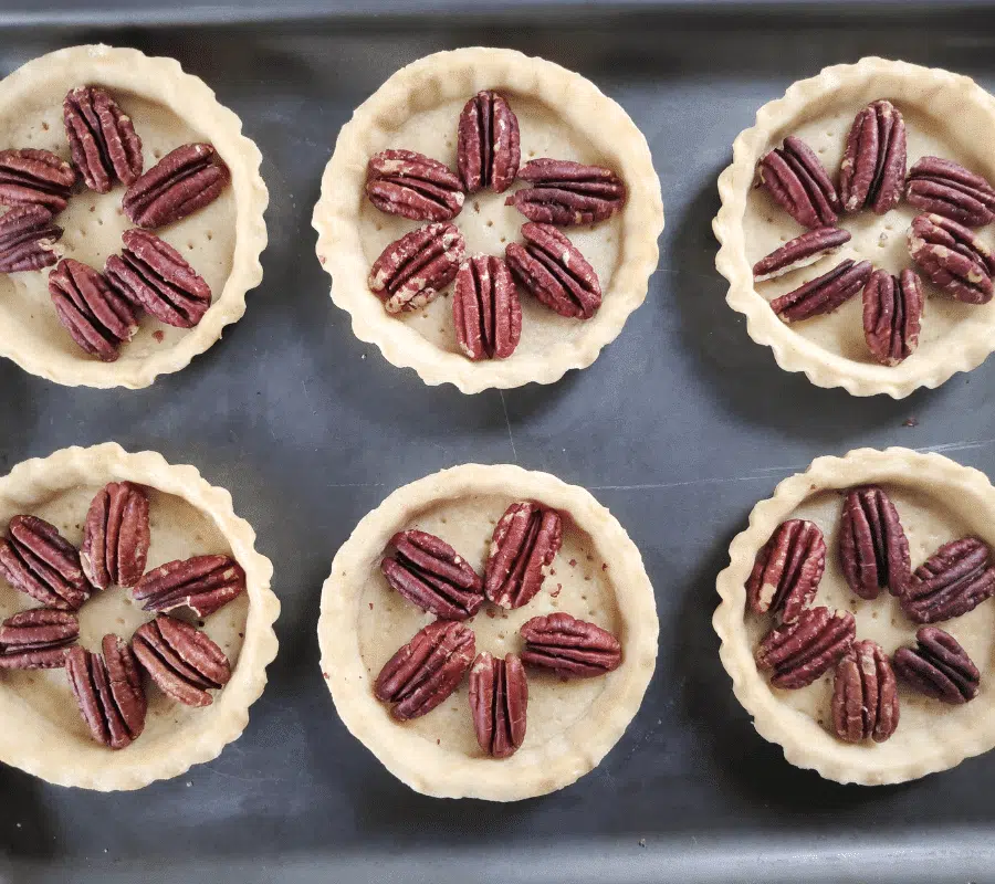 arranging pecan nuts in pastry shells