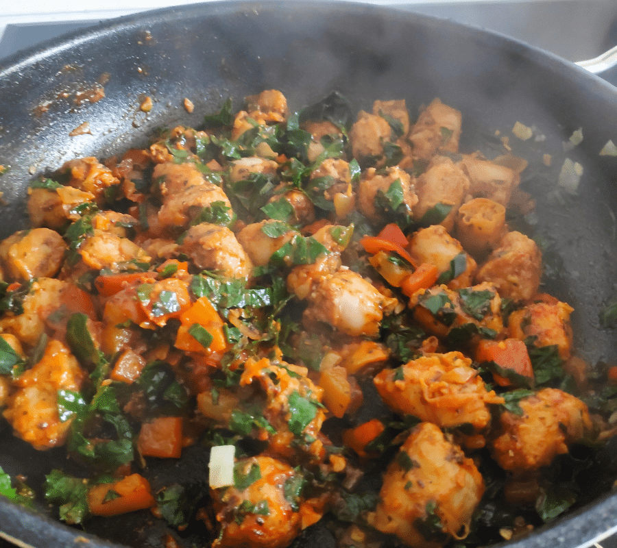 sausage and kale frying in a pan