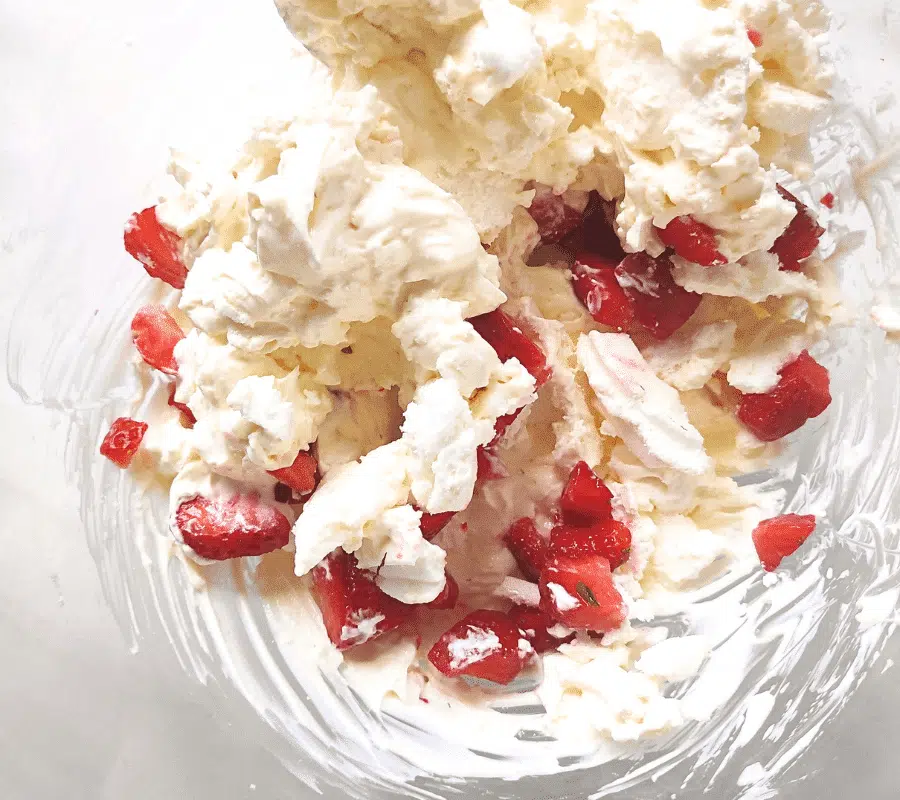 mixed cream chopped strawberries and crushed meringue in a bowl