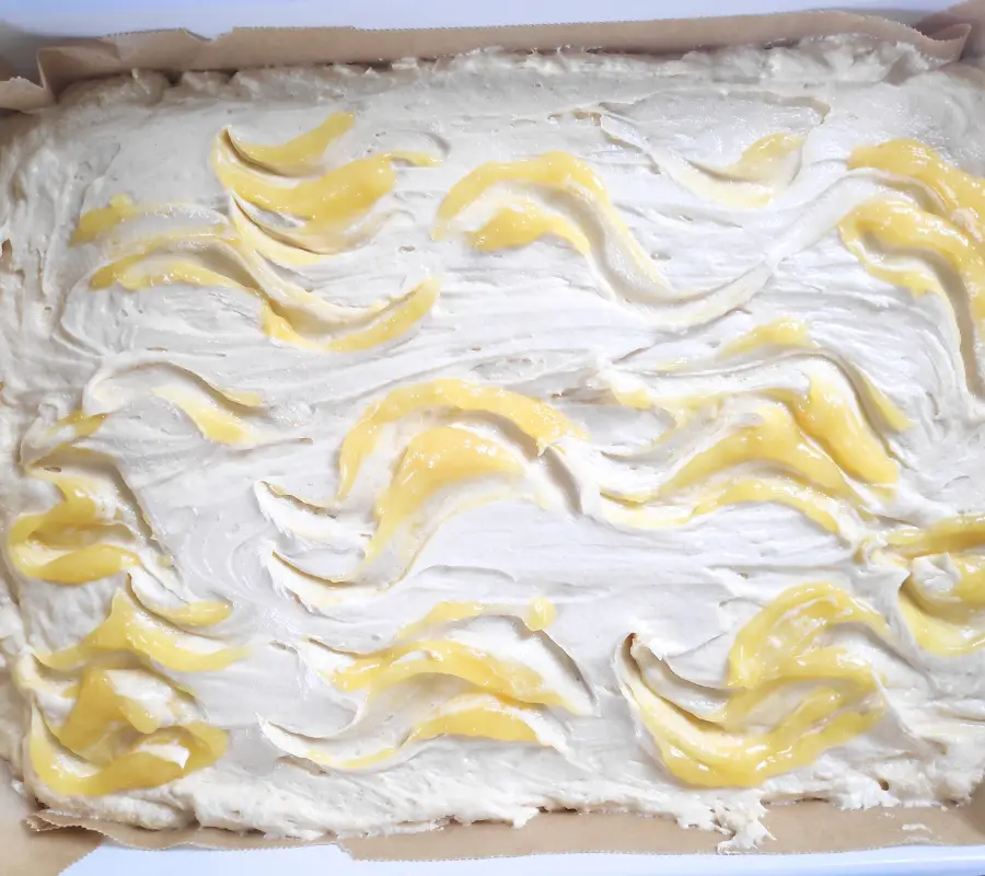 lemon curd swirled on top of sponge mixture