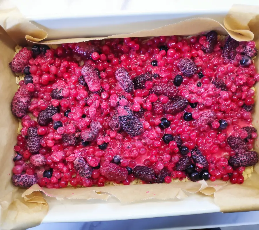 tayberries and redcurrants on top of crumble