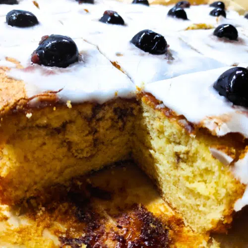 marble sponge cake topped with icing and cherries