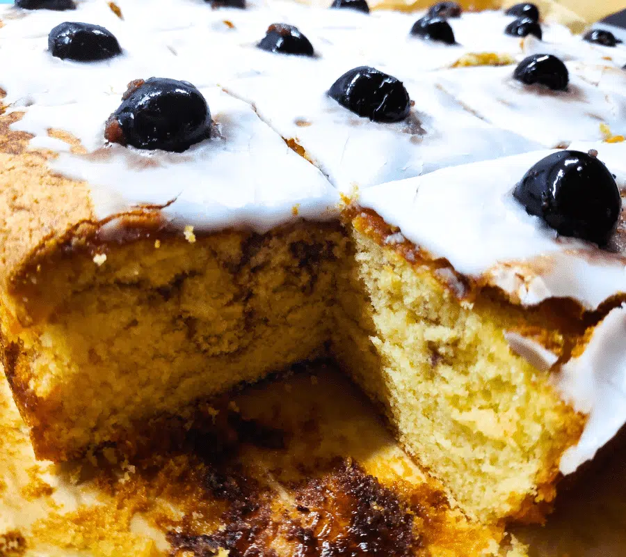 marble sponge cake topped with icing and cherries