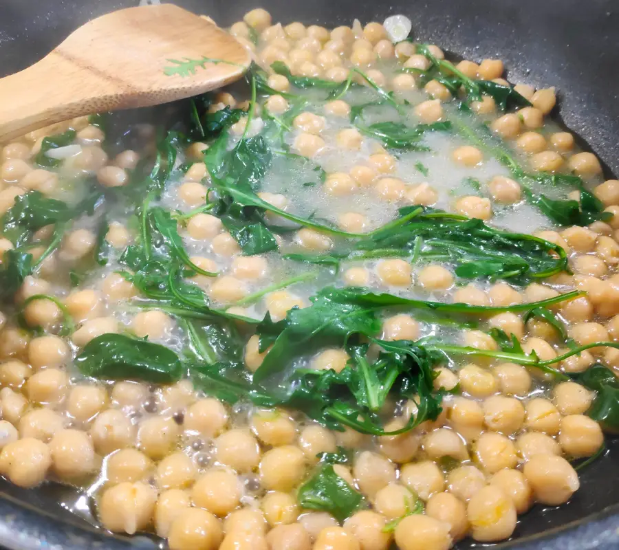 chickpeas and spinach and rocket in a pan