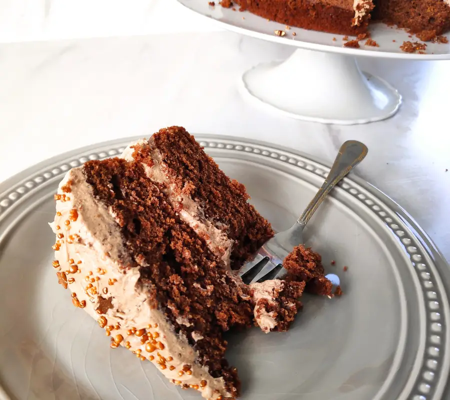slice of biscoff buttercream cake on a grey plate with serving fork