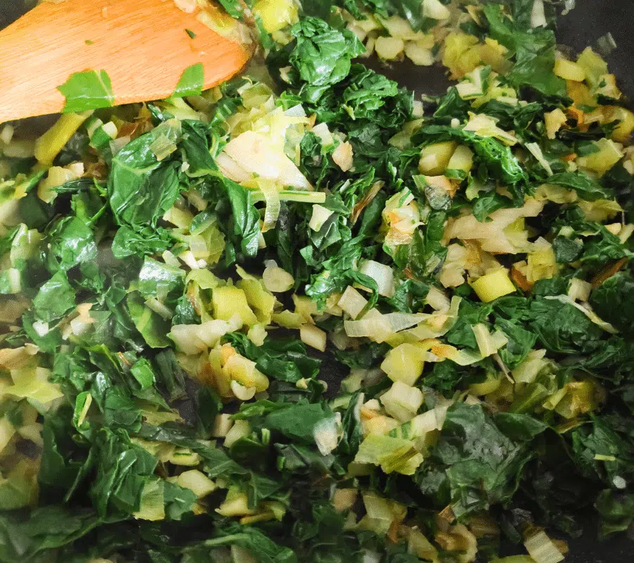 chard leaves, chard stems and leeks frying in a pan