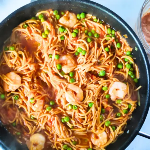 smoked prawn spaghetti pasta with peas and sauce in deep pan