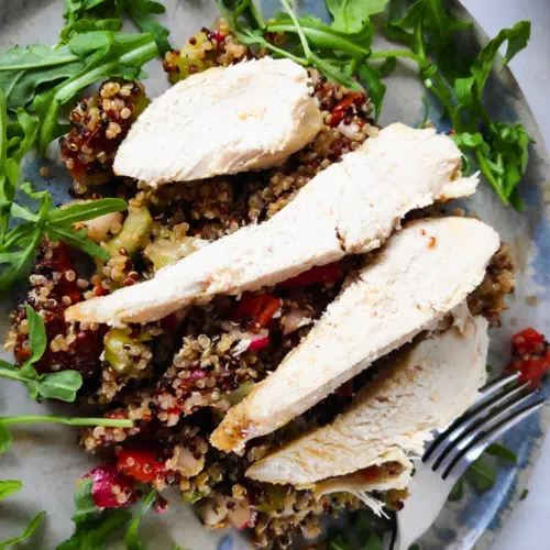 chicken quinoa salad on a plate with rocket