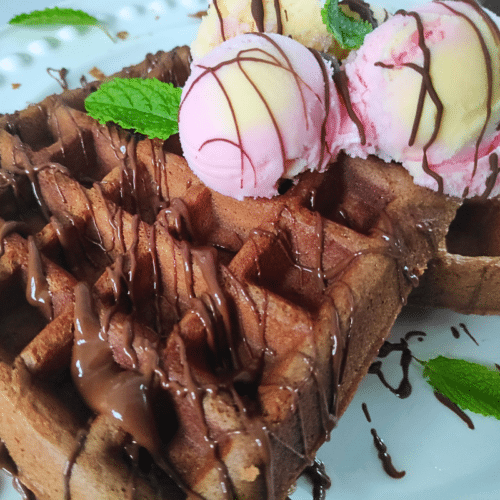 chocolate waffle topped with chocolate sauce and ice cream