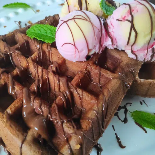 chocolate waffle topped with chocolate sauce and ice cream