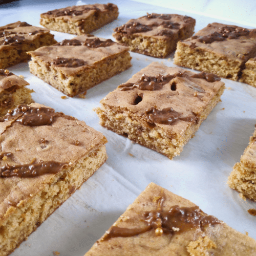 biscoff traybake cut into square pieces on a white counter