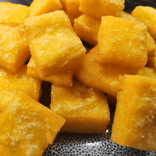 fried corn cubes on a grey plate