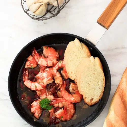 gambas pil pil tapas served in a frying pan with crusty bread