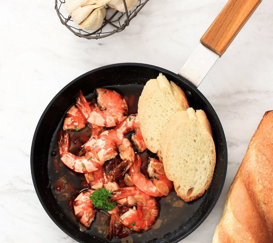 gambas pil pil tapas served in a frying pan with crusty bread