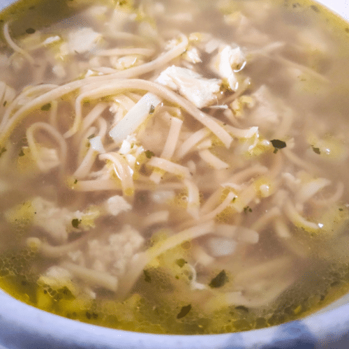 chicken and noodle soup up close in a serving bowl
