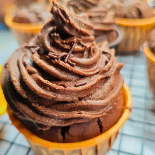 chocolate orange muffins topped with chocolate orange buttercream in a swirl