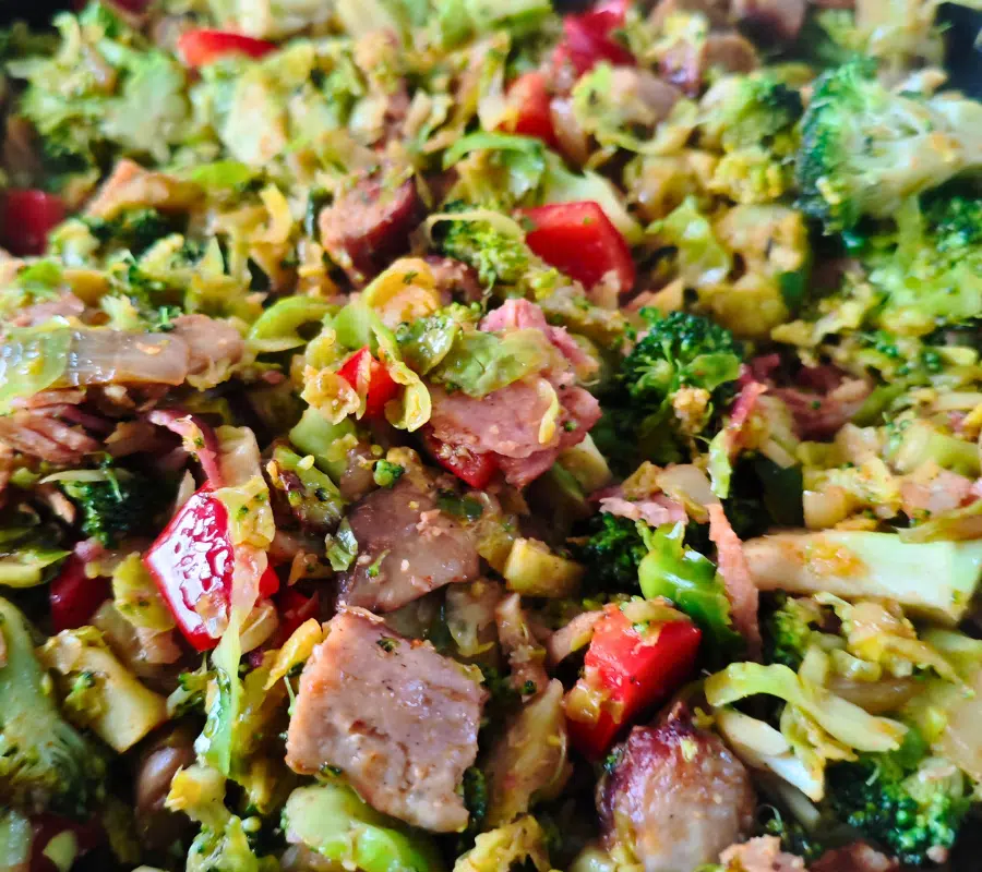 close up photo of sausage, bacon, sprouts broccoli red bell peppers stirfry