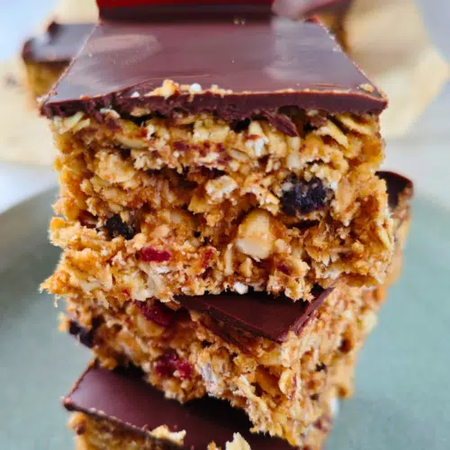 cranberry date flapjacks cut into squares and piled up in a tower of 3