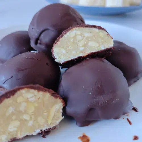 chocolate bombs on a white plate, one cut in half showing a nutty truffle centre