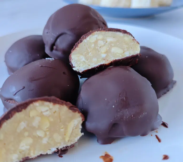 chocolate bombs on a white plate, one cut in half showing a nutty truffle centre