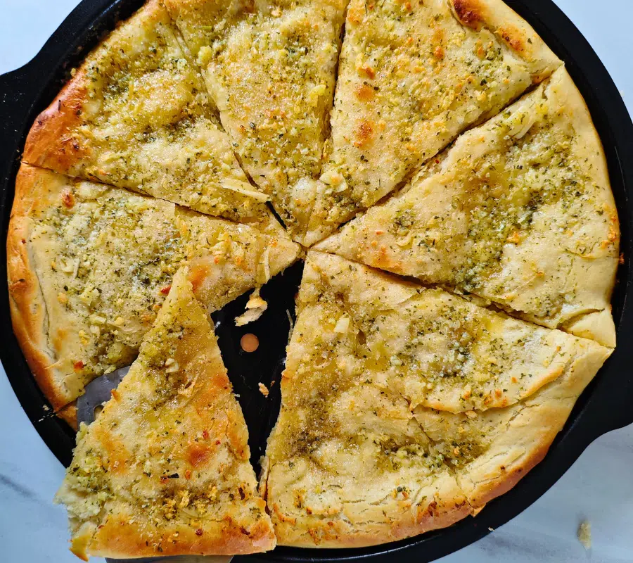 freshly made pizza garlic bread on a pizza tray all sliced ready to eat