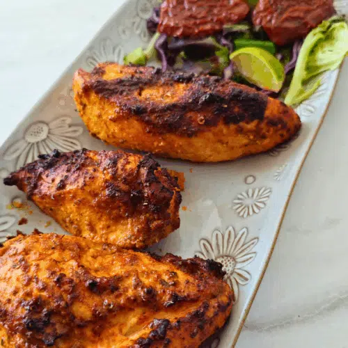 peri peri chicken breasts on a white long plate