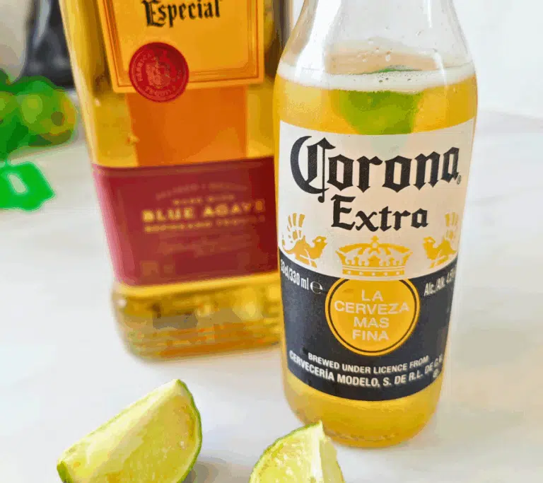 a bottle of corona, tequila and sliced limes