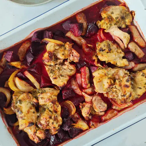 cooked chicken thighs sausage and beetroot in a tray