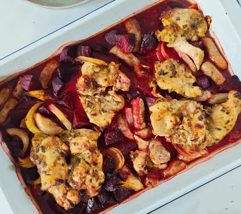 cooked chicken thighs sausage and beetroot in a tray