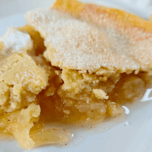 slice of homemade apple pie on a white plate
