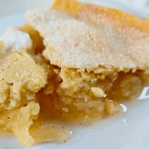 slice of homemade apple pie on a white plate