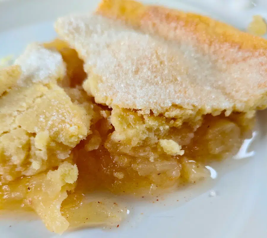 slice of homemade apple pie on a white plate