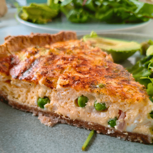 pea and bacon quiche on a plate with salad