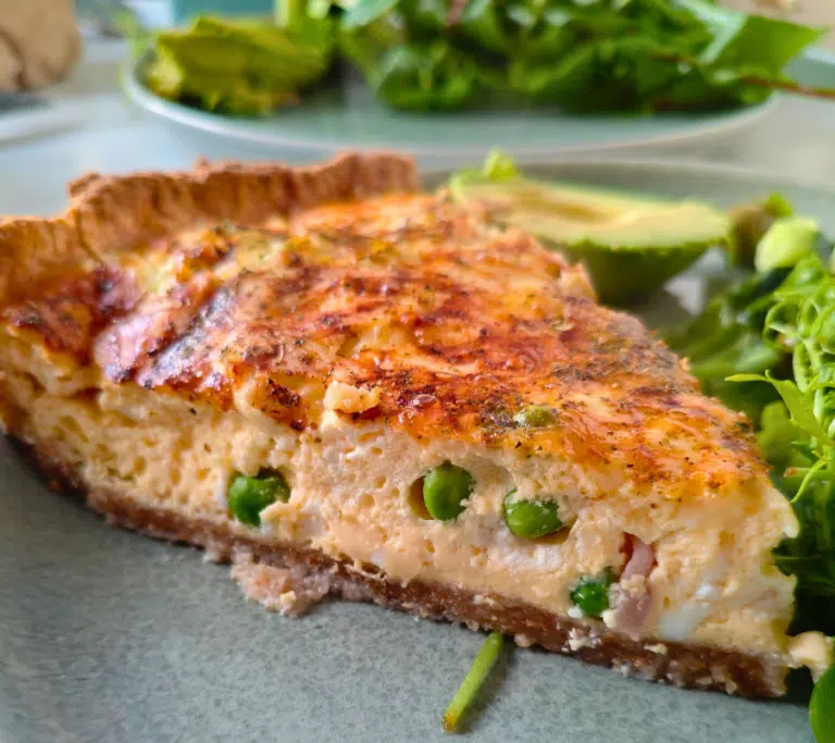 pea and bacon quiche on a plate with salad