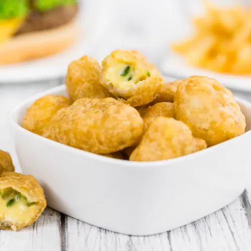 chilli cheese nuggets in a white square bowl