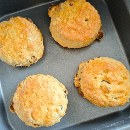 four cooked sultana scones on a air fryer baking tray
