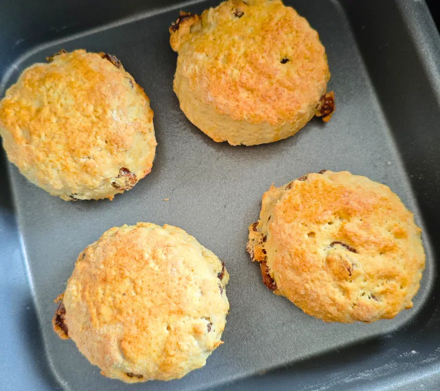 four cooked sultana scones on a air fryer baking tray