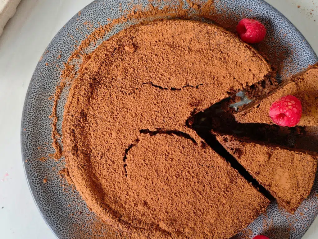 Chocolate and black bean torte dusted with cocoa powder and served with raspberries
