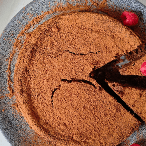 Chocolate and black bean torte dusted with cocoa powder and served with raspberries