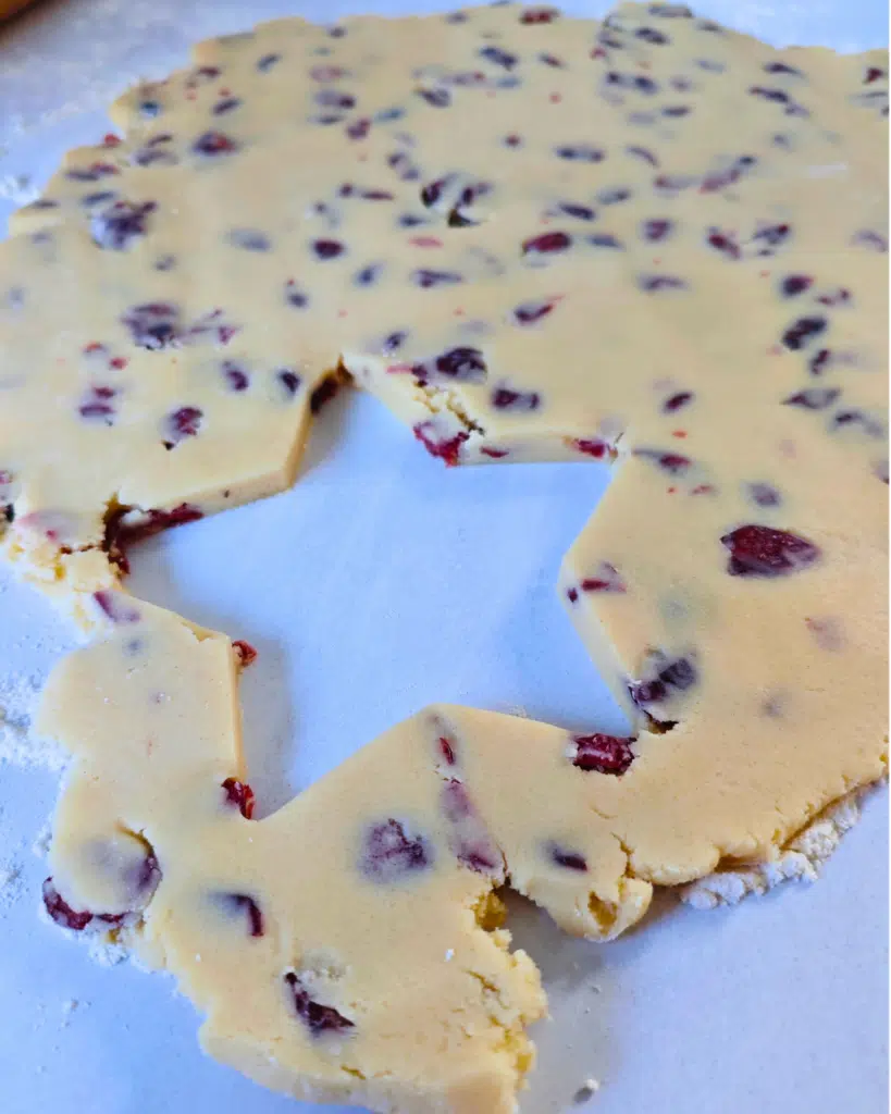 cranberry shortbread dough rolled out with a star cut out of it