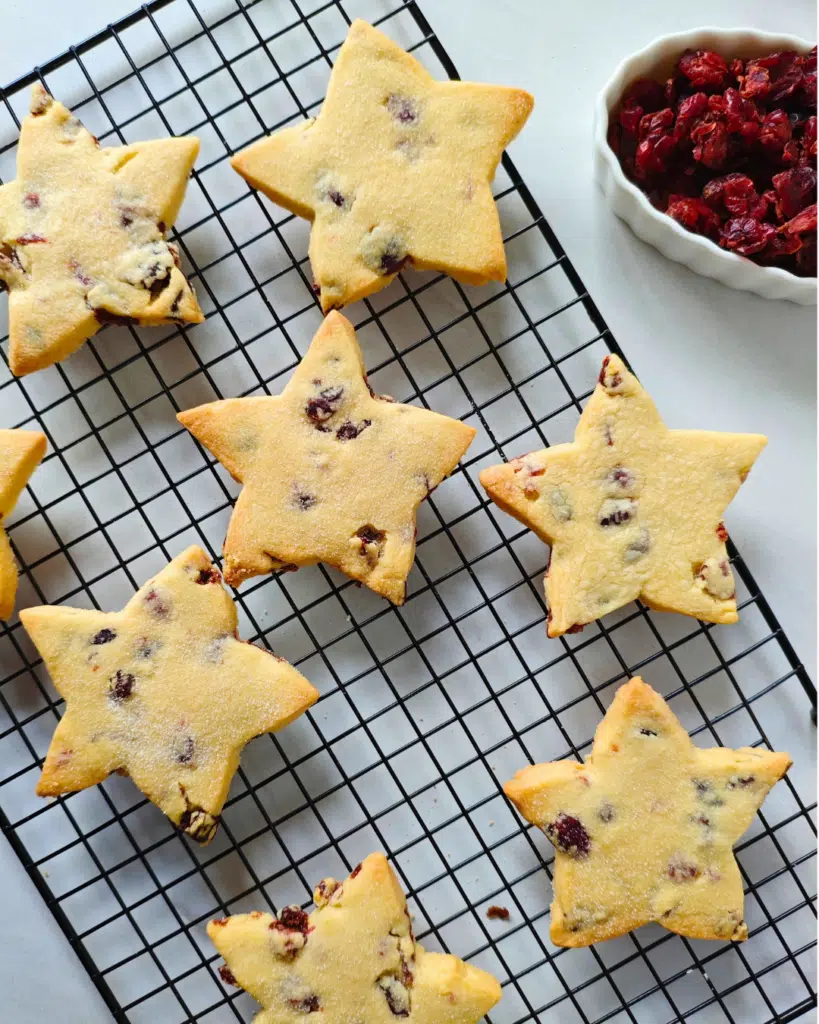 Cranberry shortbread biscuits with dried cranberries on a wire rack